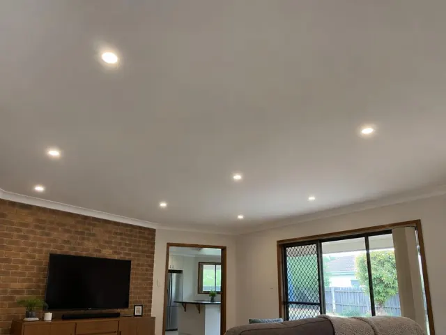 Living room ceiling with recessed downlights, brick feature wall and sliding door in Oxenford